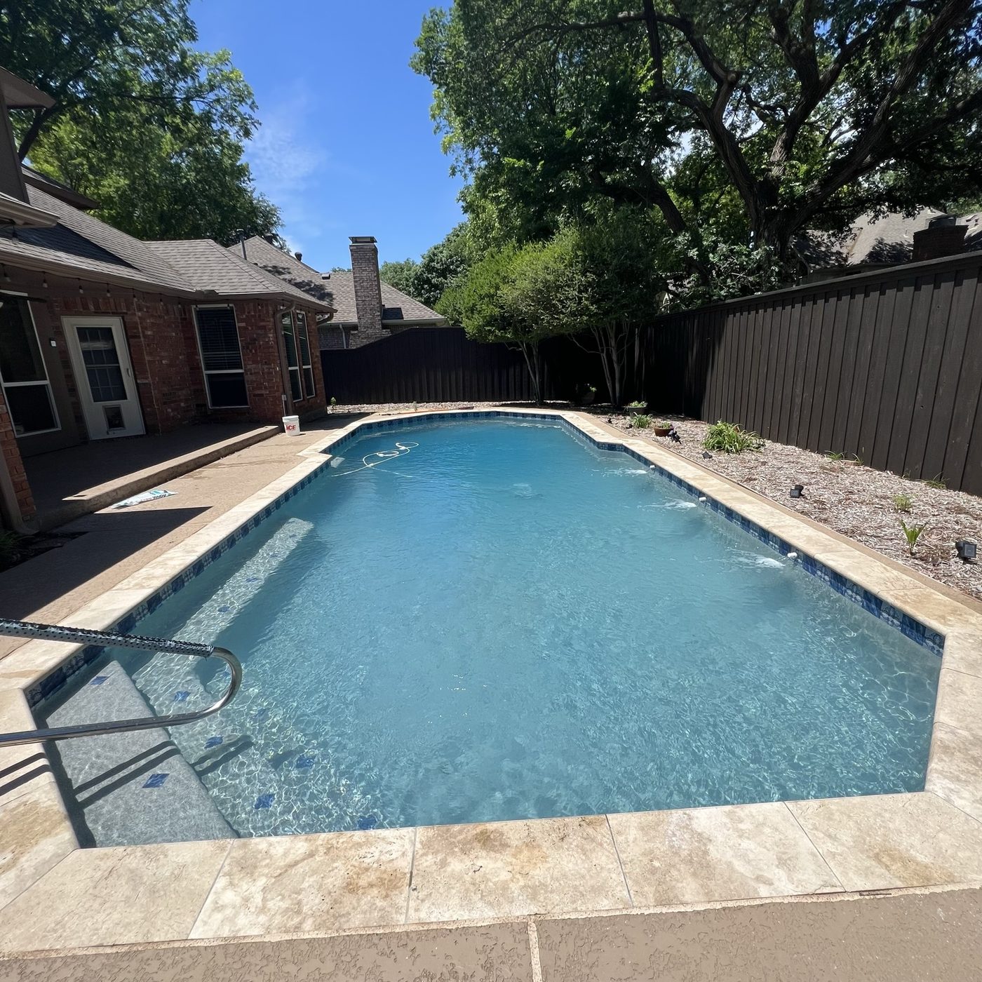 Crystal clear backyard pool cared for by Blue Flag Pool Care in North DFW