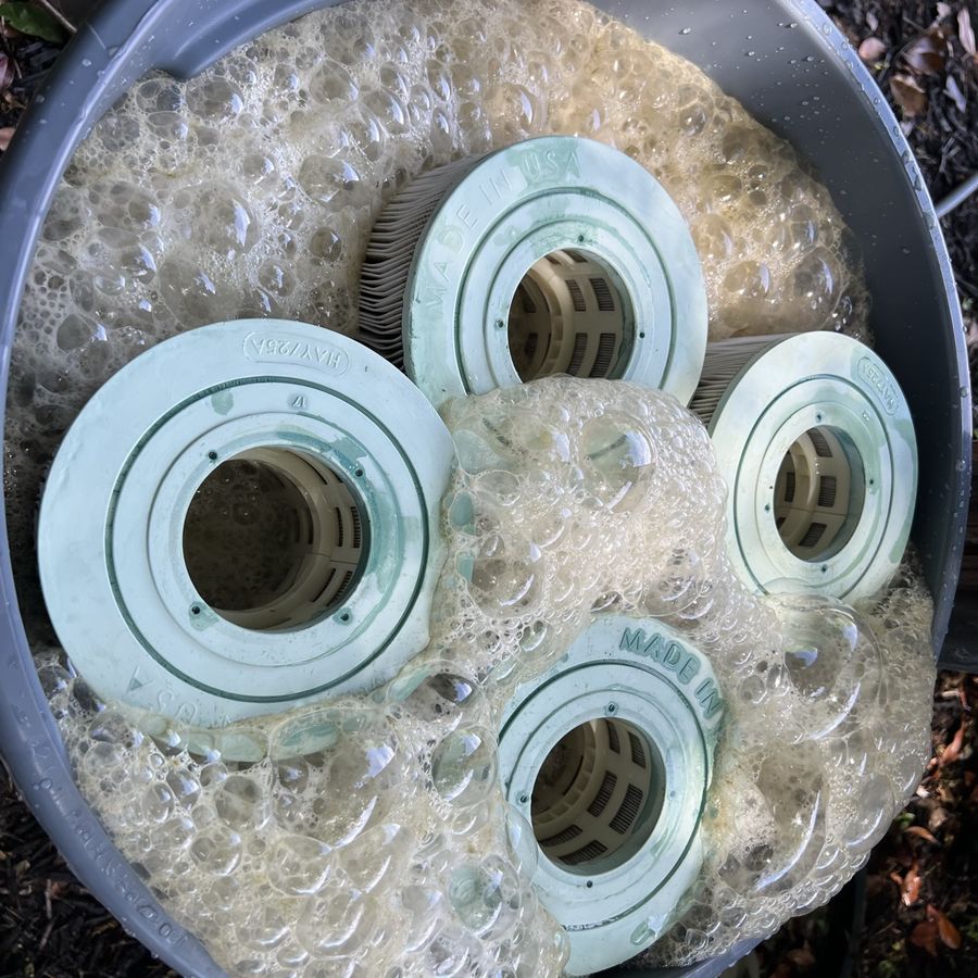 Filter cartridges soaking in a foaming degreaser bath