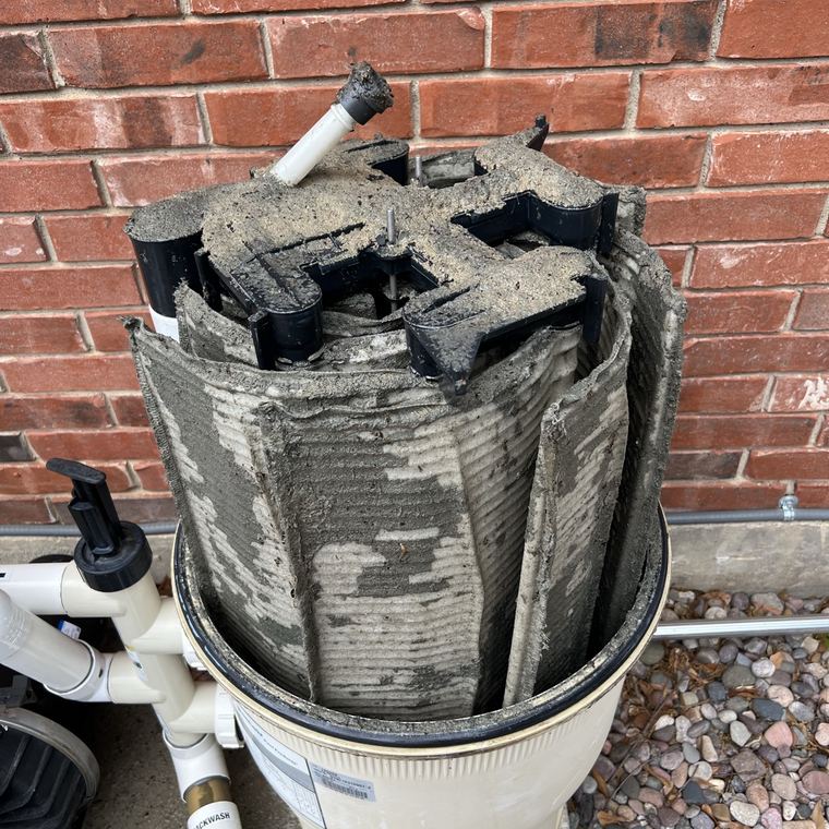 A DE filter stack caked black with debris