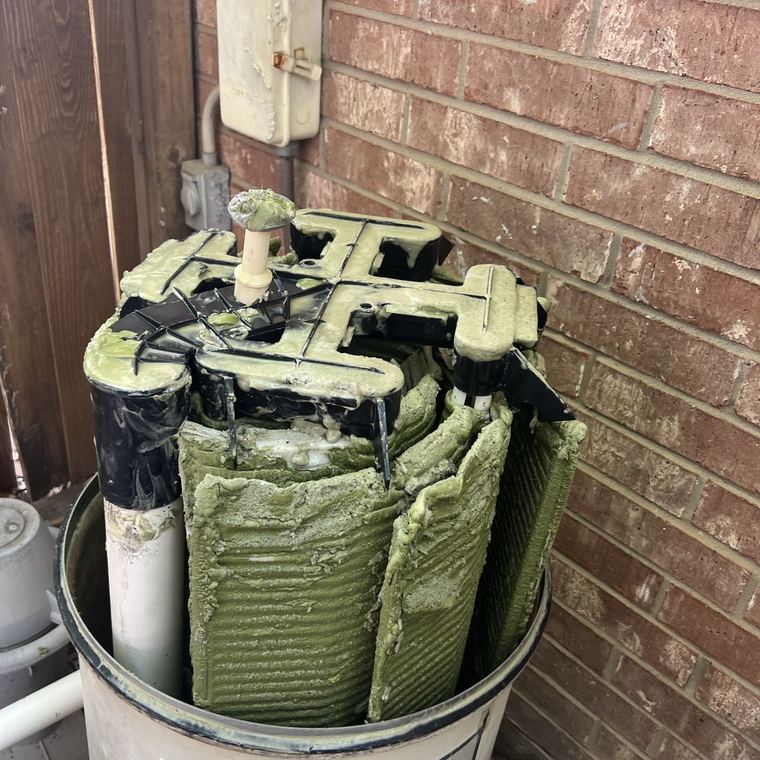 Filter elements crusted green inside an open tank