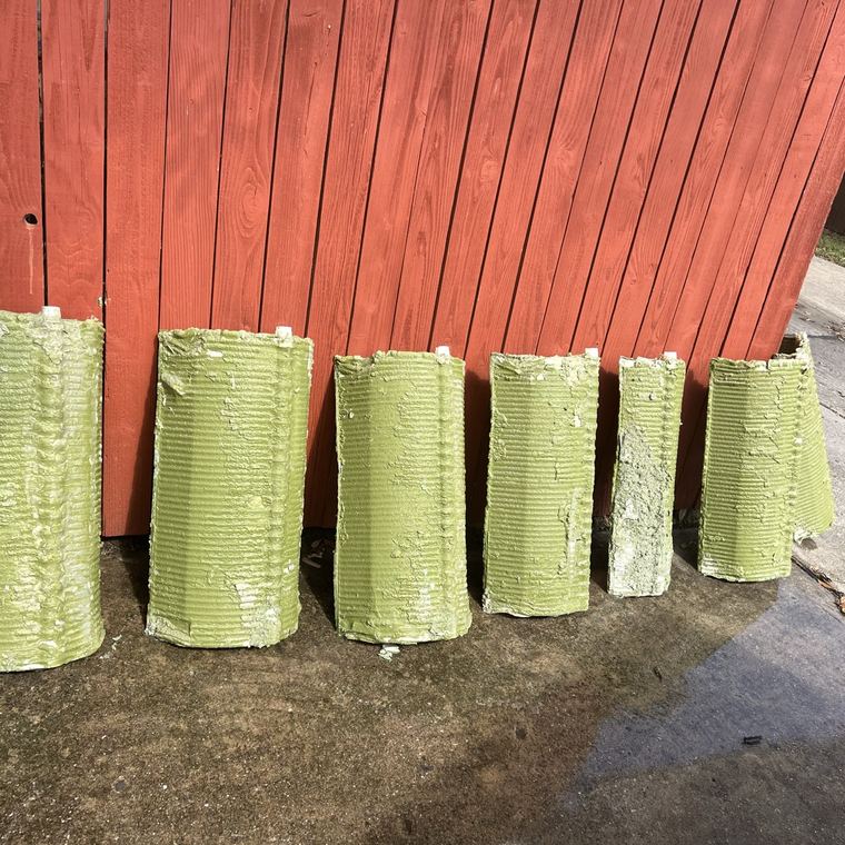 Six algae-green filter grids lined up against a fence