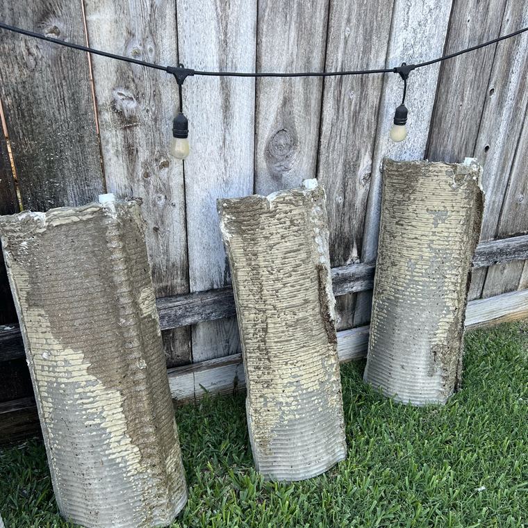 Three dirty filter grids standing on a lawn